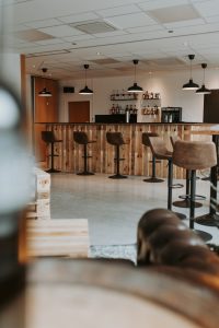 Ledercouch, Lederhocker und Bar im Hintergrund